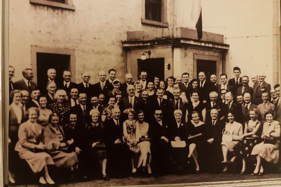 people posed in front of a building